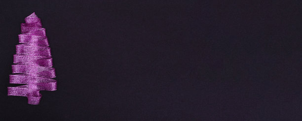 圣诞节的概念。紫色的圣诞树由丝带在黑色的背景和复制空间在顶部。明信片模板，包装图片下载