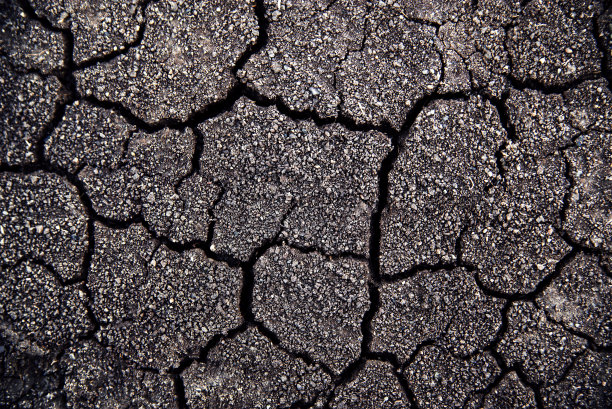 干旱时地面干裂。灰色干裂地面大地背景，接近干裂地面，裂缝表面，白色裂缝纹理，供设计师使用图片下载