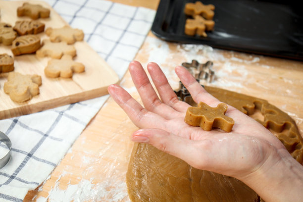 自制圣诞饼干，面包师准备姜饼饼干面团，用饼干模具手切面团，食品自制烘焙概念。图片下载
