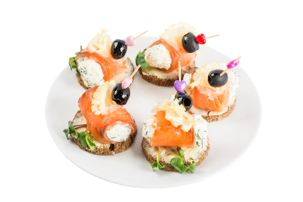 宴会食物开胃菜。软奶酪和三文鱼牙签放在盘子里，孤立在白色背景上图片下载