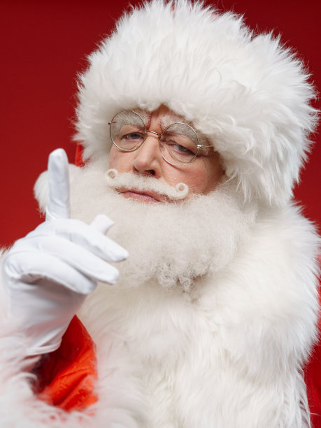 圣诞老人站在红色的背景上摇着手指图片下载