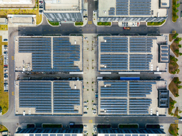 工厂屋顶上的太阳能电池板鸟瞰图。蓝色发光太阳能光伏板系统产品。图片下载