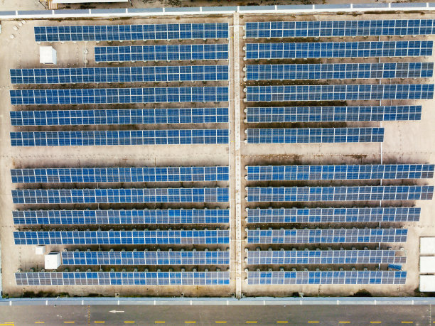 工厂屋顶上的太阳能电池板鸟瞰图。蓝色发光太阳能光伏板系统产品。图片下载