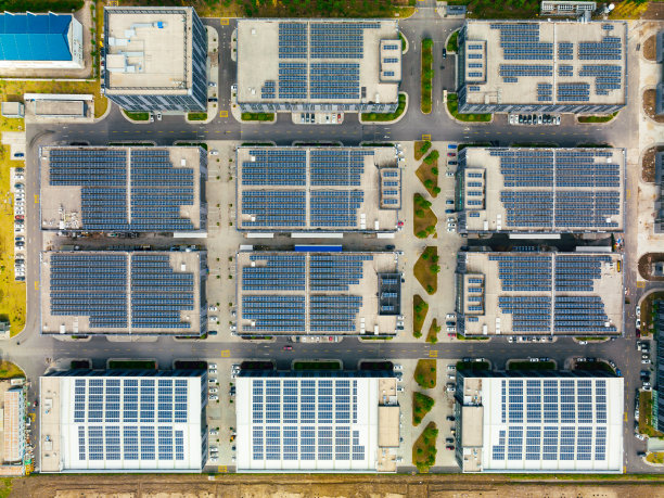 工厂屋顶上的太阳能电池板鸟瞰图。蓝色发光太阳能光伏板系统产品。图片下载