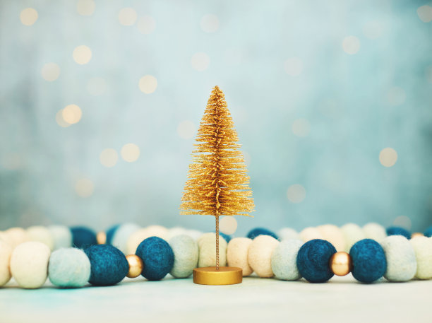 圣诞背景与蓝色和金色毡装饰和闪光的金色圣诞树。蓝色背景与文字空间素材图片