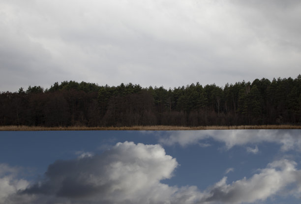 河边安静的森林。云和蓝天在河的倒影。图片下载