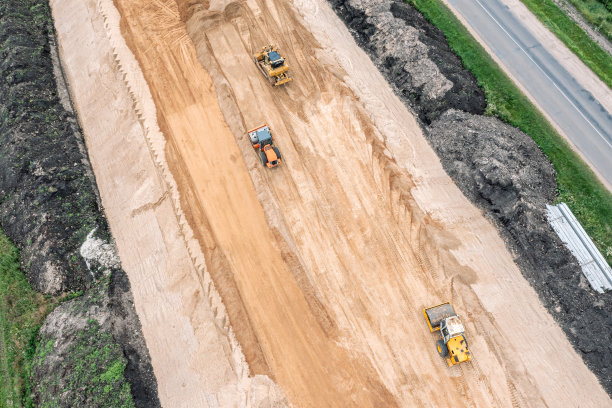 公路施工现场的鸟瞰图与工作的压路机和推土机。无人驾驶飞机的照片。图片下载