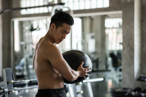 亚洲男子在健身房练习腹部球图片下载