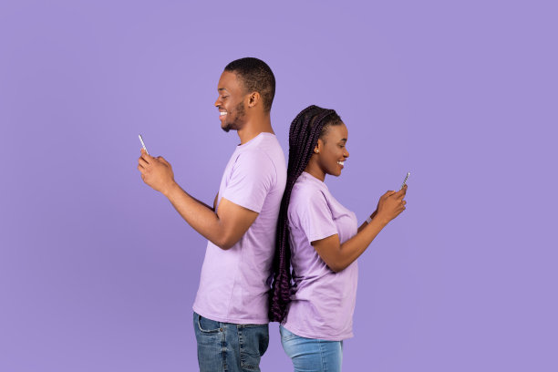 非洲裔美国夫妇使用智能手机，紫色工作室墙壁图片下载