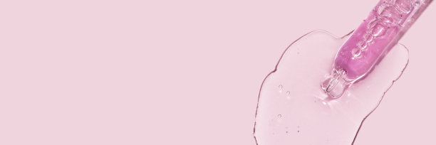 在粉红色背景上灌注面部血清的吸管滴管的特写图片下载