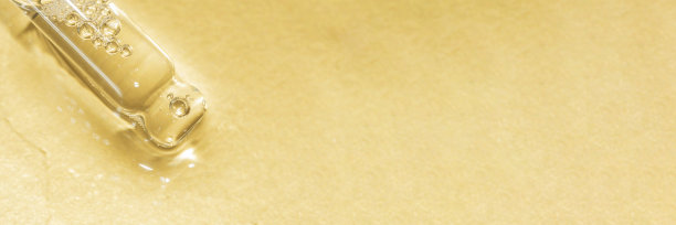 在浅金色背景上浇注液体的吸管宏图片下载