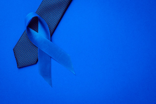 癌症的认识蓝色。蓝色丝带，时尚领带，深蓝色背景。关注男性健康前列腺癌。11月和国际男子日。图片下载