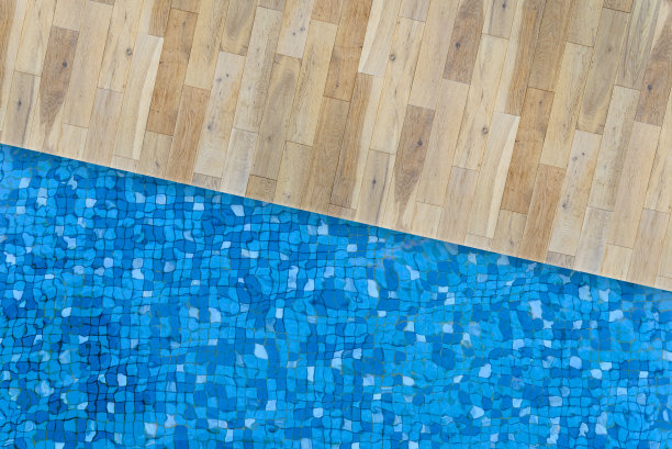 游泳池和木板的顶视图。游泳池底部蓝色马赛克瓷砖上的水波纹。图片下载