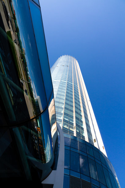 现代蓝色玻璃办公大楼摩天楼在一个大都市的商业中心与反射蓝天图片下载