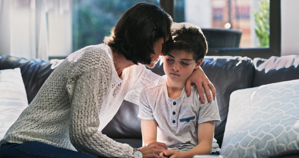 一个女人在家里安慰她心烦意乱的孩子图片下载