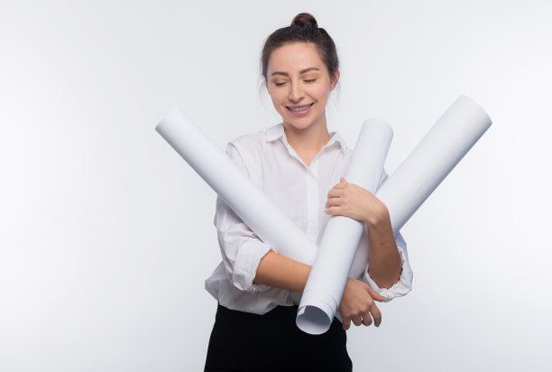 年轻可爱的女商人手里拿着设计图。她很高兴她的项目被批准了，她的工作被隔离在白色的副本空间图片下载