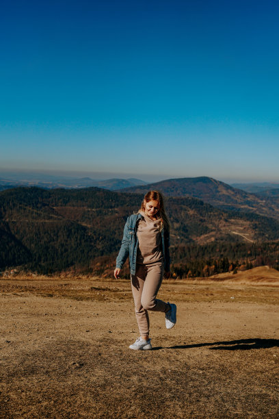 山上的秋天。快乐的女孩。自然和旅游。垂直的照片。图片下载