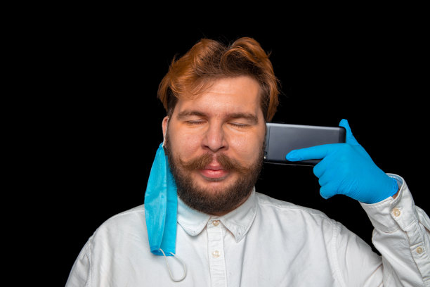 社交距离概念手机通话过程男性肖像摄影用移动设备靠近头部并取下医用呼吸面罩，复制空间图片下载