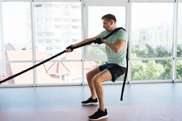 一个年轻的运动员正在一个光线充足的空间里用绳子训练图片下载