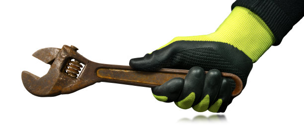 戴着防护手套的手拿着生锈的活动扳手图片下载