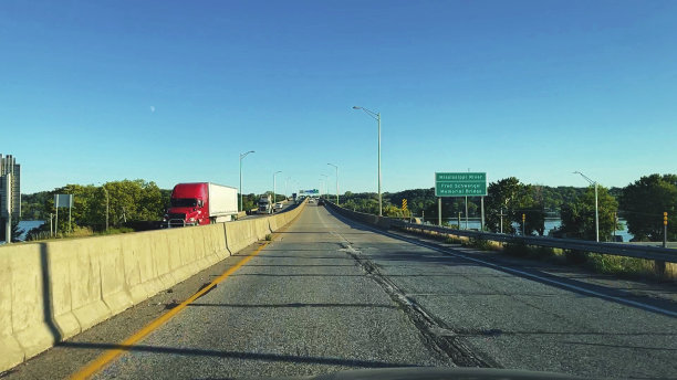 在美国中西部州际公路上的河流穿越白天旅行货物运输长途半卡车照片系列图片下载