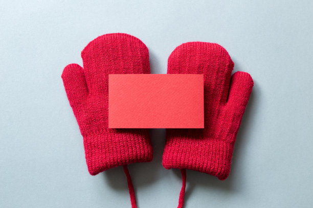 空白卡片和冬季红色针织手套在灰色的背景。俯视图，复制空间图片下载