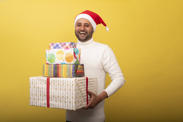 年轻人作为圣诞老人和抱着礼物的股票照片图片下载