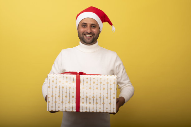 年轻人作为圣诞老人和抱着礼物的股票照片图片下载