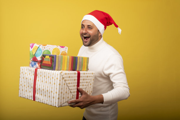 年轻人作为圣诞老人和抱着礼物的股票照片图片下载