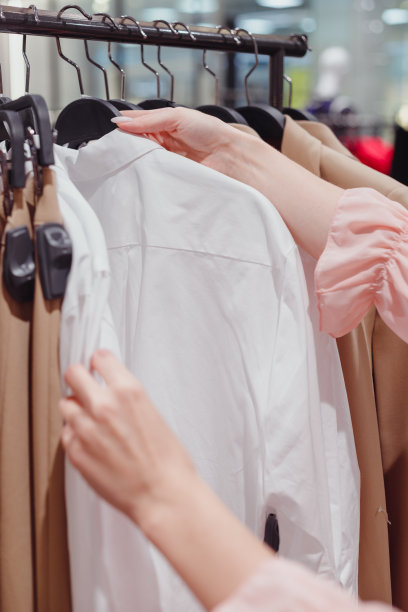 妇女在时尚商场购物，挑选新衣服图片下载
