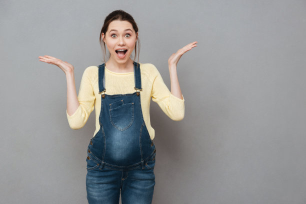 微笑的孕妇手里拿着copyspace。图片下载