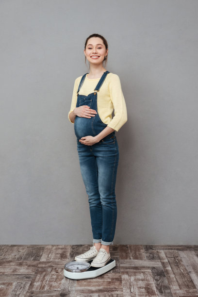 美丽开朗的孕妇在天平上图片下载