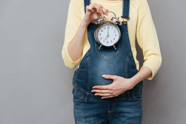 裁剪的照片怀孕的女人拿着时钟图片下载