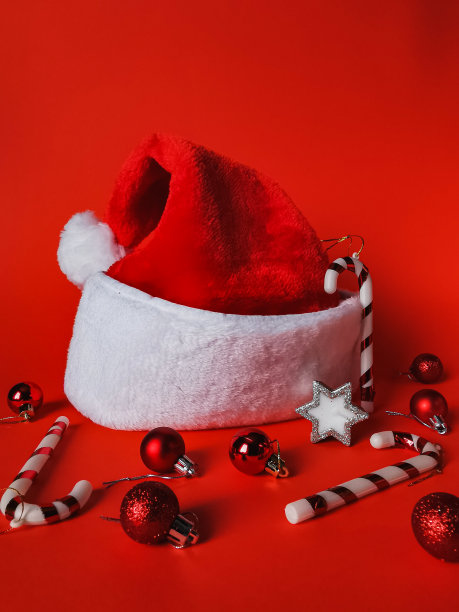 圣诞和新年的装饰，圣诞老人的帽子在红色的背景图片下载
