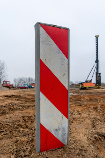 建筑工地指示牌照片。背景是建筑工地。图片下载