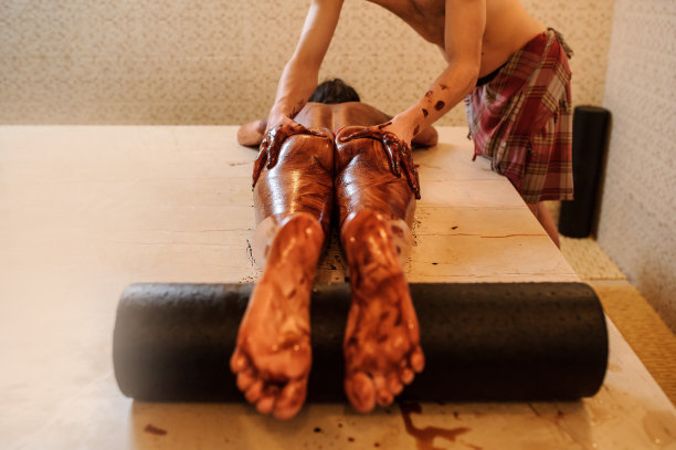 一个年轻的女人在她的屁股上和腿上被一个男人按摩的照片图片下载