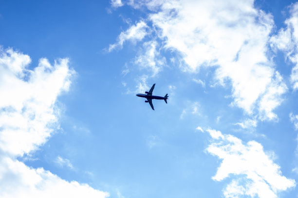 飞机在云层中飞行。蓝色的天空。阳光灿烂的日子图片下载