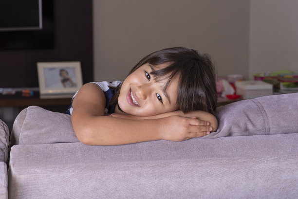 快乐漂亮的小女孩躺在沙发上。
感到快乐和平静图片下载
