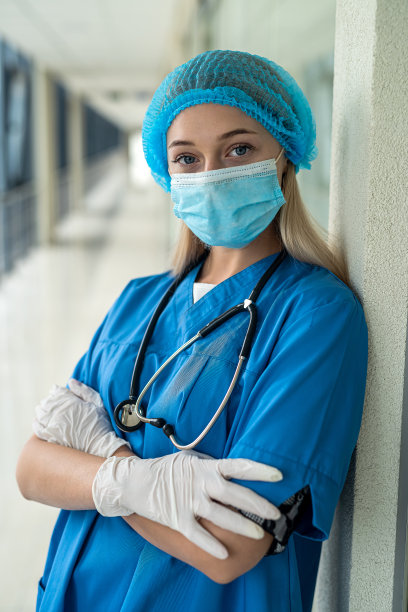 年轻漂亮的护士戴着面具站在走廊里图片下载