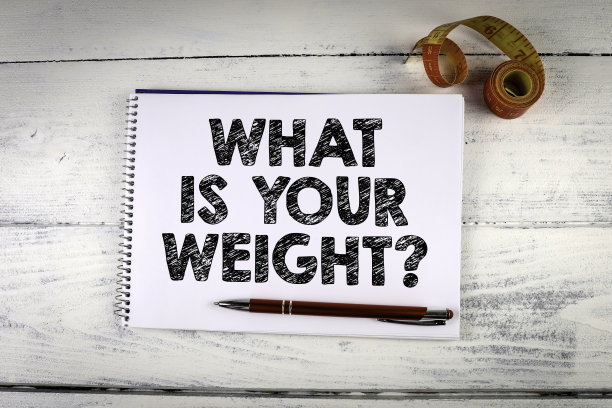 你的体重是多少?记事本和卷尺在白色木制背景图片下载
