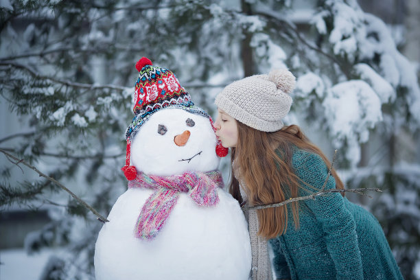可爱的女孩正在堆雪人图片下载