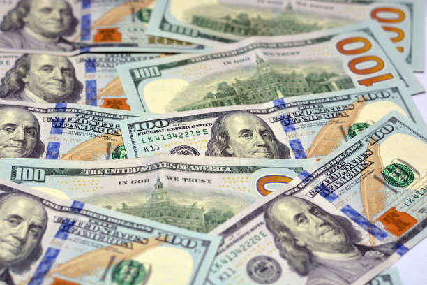 一叠100美元纸币的肖像，100美元纸币的观察面是本杰明·富兰克林的照片，背面是费城独立大厅的图像图片下载