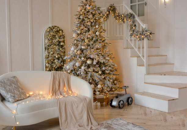 圣诞节的房间。白色的沙发，枕头，格子图案和花环，背景是装饰精美的圣诞树和楼梯。新年快乐，圣诞快乐!图片下载