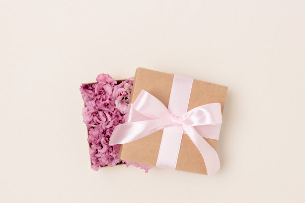 带蝴蝶结的礼物。打开的盒子里面有花。图片下载