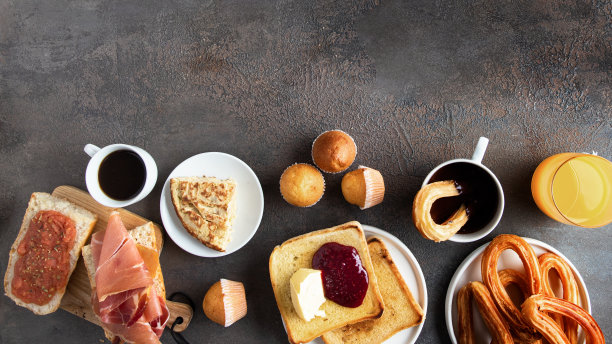 西班牙早餐种类。玉米饼、意式烤面包加火腿和番茄、硬面包加黄油和果酱、松饼、咖啡和橙汁。横幅的大图像。图片下载