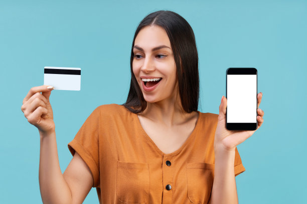 快乐微笑的黑发女孩的肖像持有塑料信用c图片下载