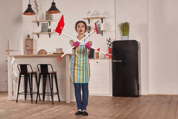 有趣的照片，棕发女子拿着铲子和扫帚。她假装那是剑。女孩准备好战斗了图片下载