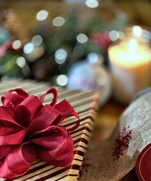 圣诞节礼物的一部分与红色的蝴蝶结旁边的粗麻布丝带包装桌上-股票照片图片下载