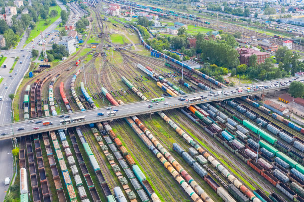 铁路编组场和公路桥上面都有车辆。进出口物流。工业景观。铁路的鸟瞰图，五颜六色的货车。图片下载
