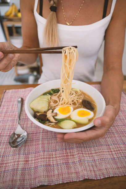 一位妇女在家里吃日本拉面图片下载